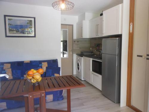 une cuisine avec une table avec un bol de fruits dessus dans l'établissement APPT 2 PIECES 21m2 + TERRASSE 26m2 REF 4052, à Le Castellas