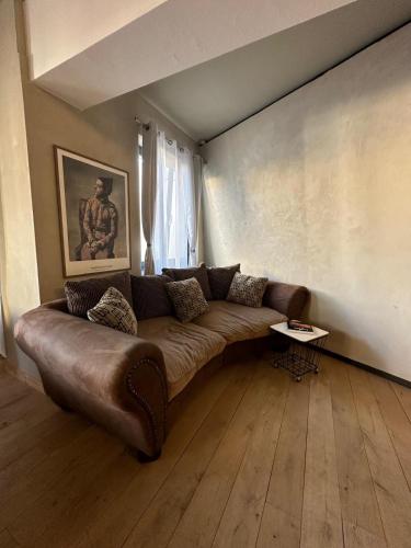 a living room with a brown couch in a room at Mulhouse City Loft in Mulhouse