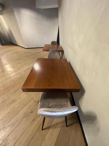 a wooden table with a chair next to a wall at Mulhouse City Loft in Mulhouse