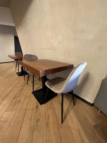 a table and chairs in a room with a wall at Mulhouse City Loft in Mulhouse