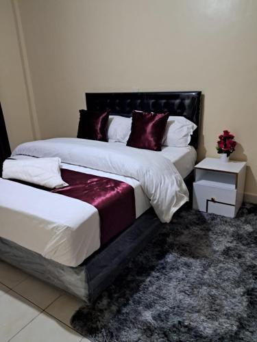 dwa łóżka siedzące obok siebie w sypialni w obiekcie Tirisi Homes w mieście Machakos