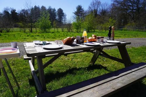 a picnic table with food on it in a field at Luxe Glamping Met eigen badkamer voor 5 Personen Bashful in Behelp