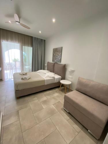 a bedroom with two beds and a couch at Villa Panorama Astrakeri Beach in Astrakeri