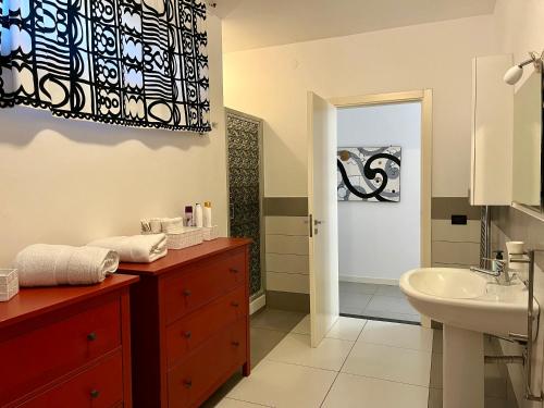 een badkamer met een wastafel, een toilet en een spiegel bij Flat with Terrace & Pool in Mondello