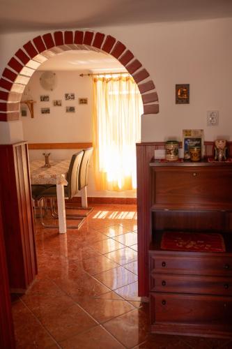 an archway in a room with a table and a dining room at Európa Szíve vendégház in Tállya