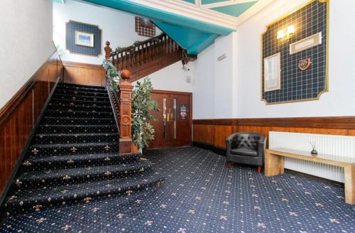 a staircase in a building with a chair and a couch at Carlton Hotel in Forres