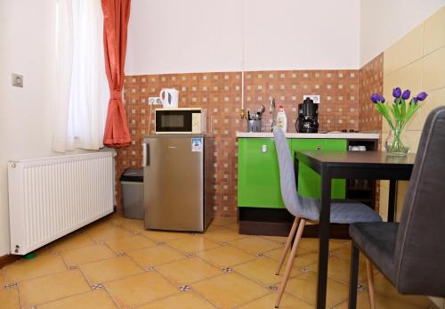 cocina con mesa y nevera pequeña en Makotel Apartmanház, en Makó