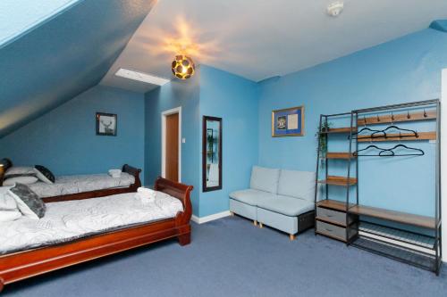 a blue room with two beds and a chair at Carlton Hotel in Forres