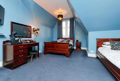 a bedroom with a bed and a desk with a mirror at Carlton Hotel in Forres