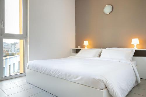 a white bed in a room with a window at Hotel Campus Sanpaolo in Turin