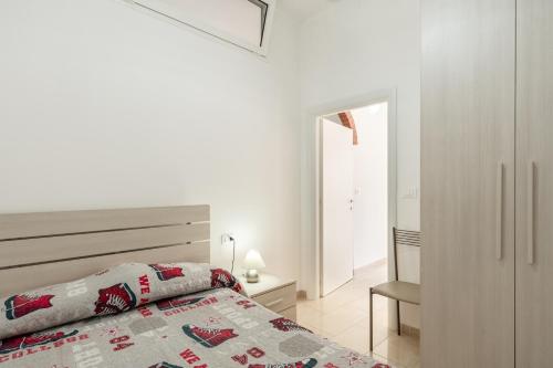 um quarto branco com uma cama e uma cadeira em Casa Prataccio em Prataccio