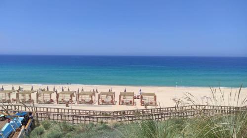 a view of a beach with a resort and the ocean at Cabanas de Melides in Melides