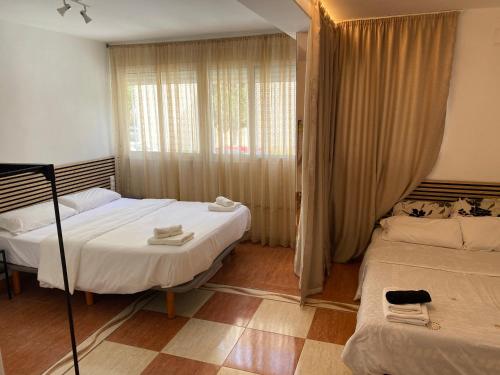 a bedroom with two beds and a window at Habitaciones con baño y cocina privada in Valencia