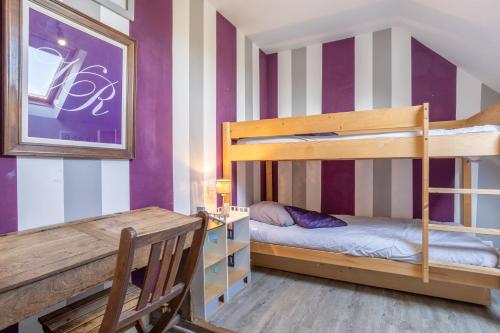 a bedroom with two bunk beds and a table at La bonne descente in Fouesnant