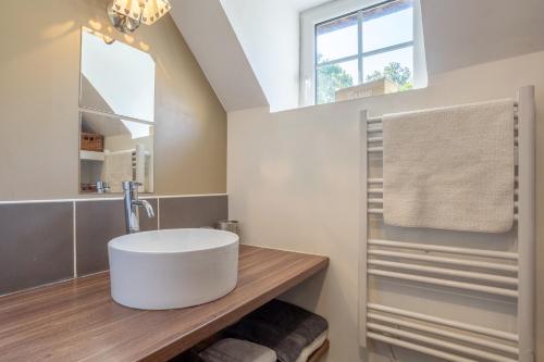 a bathroom with a large white sink and a window at La bonne descente in Fouesnant