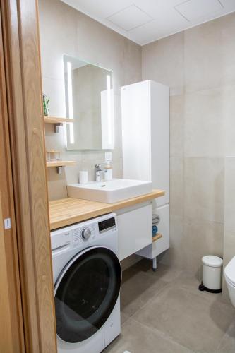 a bathroom with a washing machine and a sink at Modern Niidu Apartment in Pärnu