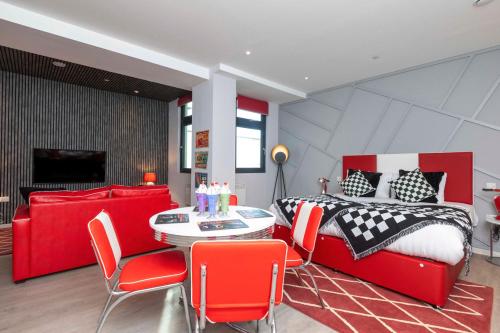 a bedroom with a red bed and a table and chairs at PALM TREE HOUSE - DINER in Orpington