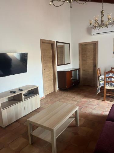 a living room with a coffee table and a tv at Casa dos Sapos in Mértola