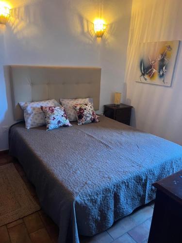 a bedroom with a bed with blue sheets and pillows at Casa dos Sapos in Mértola