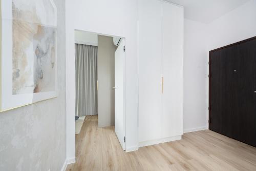 a hallway with white walls and a black door at Sol Marina Resort Wyspa Sobieszewska II - LoftAffair Collection in Wiślinka