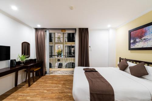 a bedroom with a bed and a desk and a television at KA VILLA - AN BANG BEACH, Free pick up 3 nights in Hoi An