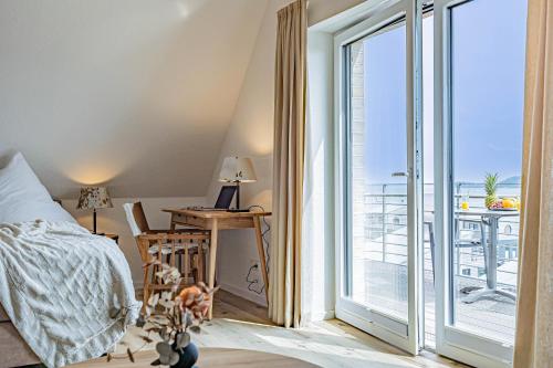 - une chambre avec un lit et un bureau à côté d'une fenêtre dans l'établissement Ferienwohnung Wiking-Koje 10 Schleswig, à Schleswig