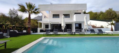 Villa con piscina frente a una casa en Bella Galera en Altea