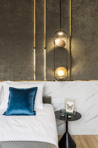 a bedroom with a bed with a blue pillow and a table at Sol Marina Resort Wyspa Sobieszewska II - LoftAffair Collection in Wiślinka