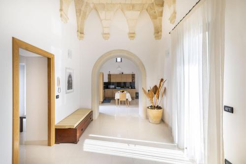 un couloir avec une arche et une salle à manger dans l'établissement Casa Pizzicchia, à Muro Leccese