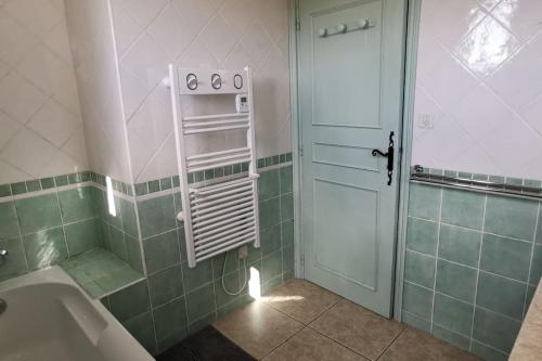 La salle de bains est pourvue d'une baignoire et d'une porte blanche. dans l'établissement Villa piscine Ventoux Provence, à Malaucène
