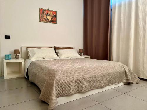 een slaapkamer met een bed met een bruine en witte deken bij Flat with Terrace & Pool in Mondello