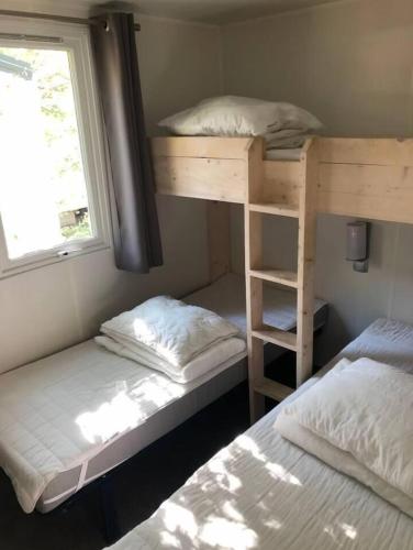 une chambre avec deux lits superposés et une fenêtre dans l'établissement Campsite chalet France at Cotes d'Azur nearby sea, à Roquebrune-sur Argens