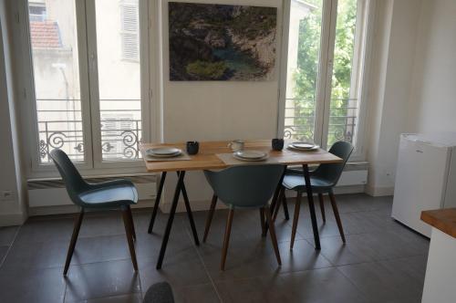 une salle à manger avec une table et quatre chaises dans l'établissement Appartement Suite Privilège avec Parking, à Salon-de-Provence