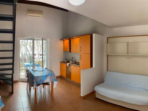 a bedroom with a bed and a table and a kitchen at Villini Frutteto in Castellaneta Marina 