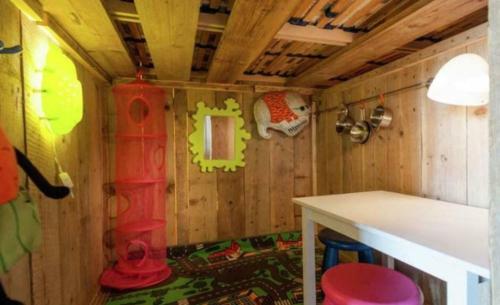 a small room with wooden walls and a table in a house at Veluwe Luxe Glamping In de natuur voor 6 personen LL94 in Putten