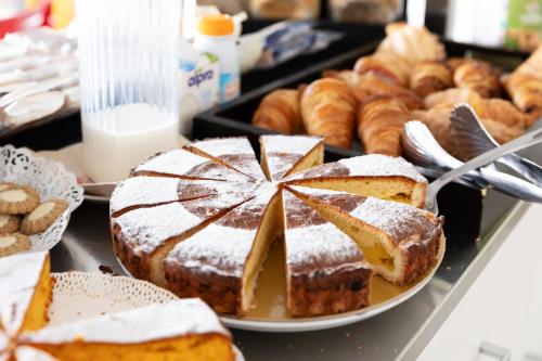 a table topped with cakes and other pastries and bread at Hotel Campus Sanpaolo in Turin