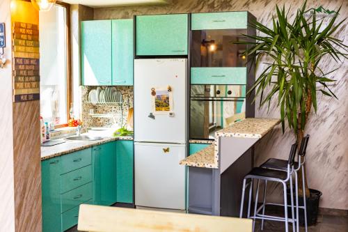 a kitchen with blue cabinets and a white refrigerator at Докторската къща in Sapareva Banya