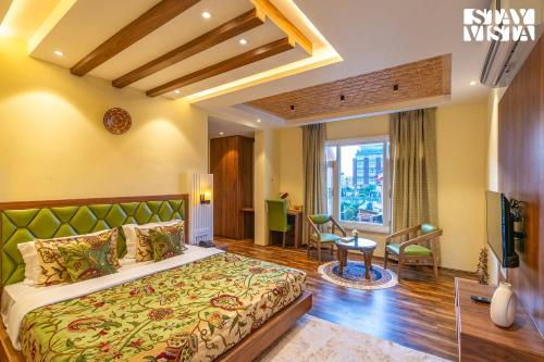 a bedroom with a large bed and a living room at StayVista at Gauhar with Projector Set-up, Steam Room & Indoor Jacuzzi in Srinagar