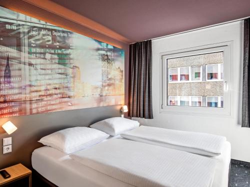 ein Schlafzimmer mit 2 Betten und einem Wandgemälde in der Unterkunft B&B Hotel Hamburg-Airport in Hamburg