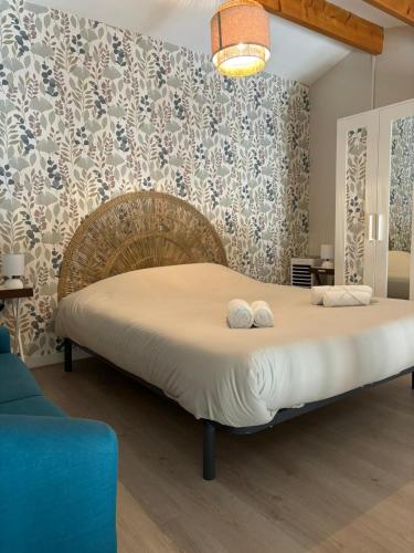 une chambre avec un lit avec deux serviettes dessus dans l'établissement La Parenthèse Rochelaise, à La Rochelle