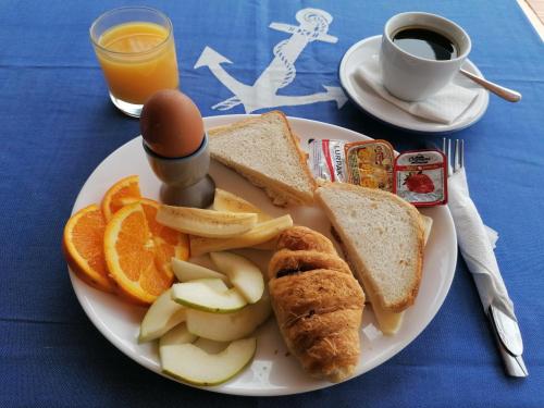 a plate of breakfast food with bread and fruit and a cup of coffee at Mirabella Apartments in Agios Nikolaos