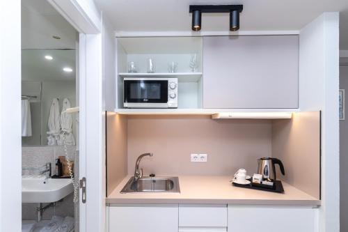 una pequeña cocina con fregadero y microondas en Hotel LIVVO Anamar Suites en Playa del Ingles