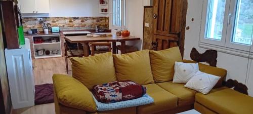 ein Wohnzimmer mit einer gelben Couch in einer Küche in der Unterkunft Casa rural en Asturias in Bimenes