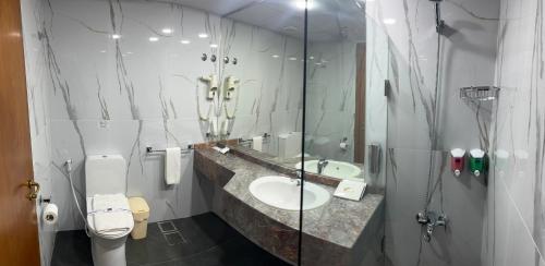 y baño con lavabo, aseo y espejo. en El Sheikh Suites Hotel en Beirut