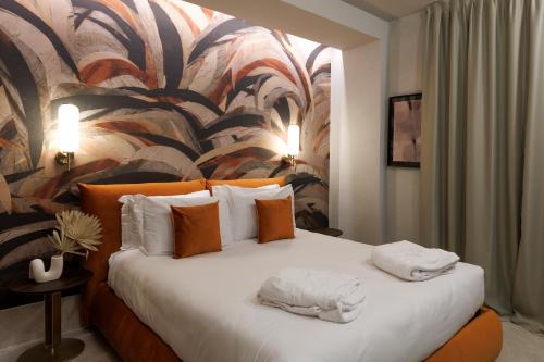 una camera d'albergo con un letto e asciugamani di Palazzo Bellezia Luxury Suites a Torino