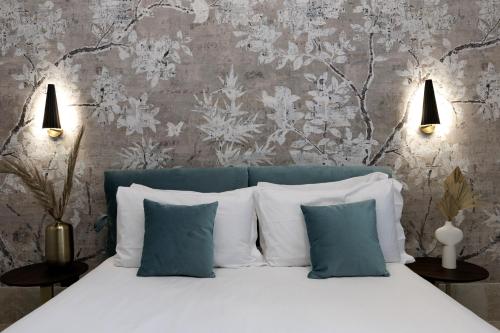 a bedroom with a bed with blue and white pillows at Palazzo Bellezia Luxury Suites & Spa in Turin