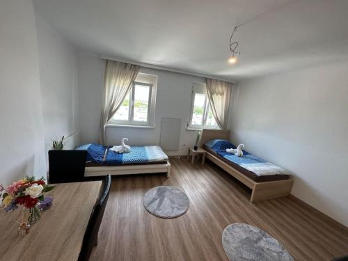 a room with two beds and a table in it at Quiet Apartment near Airport Vienna in Schwechat