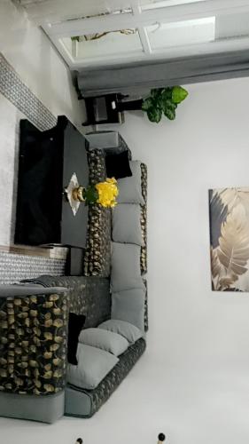 Appartement meublé في قسنطينة: غرفة بها كومة من الوسائد و زهرة