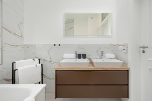 a bathroom with two sinks and a refrigerator at Sunny Hills Villas - Kołobrzeg by Jantar Apartamenty in Kołobrzeg