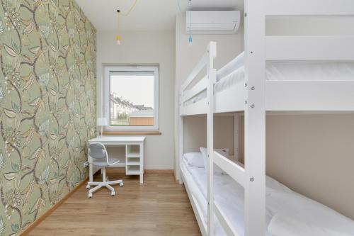 a bedroom with two bunk beds and a desk at Sunny Hills Villas - Kołobrzeg by Jantar Apartamenty in Kołobrzeg